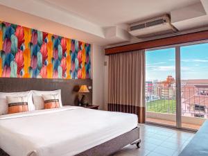 南芭堤雅Piyada Residence Pattaya的一间卧室设有一张大床和一个大窗户