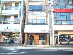 韮崎市chAho Hostel Nirasaki / Outdoor Base的建筑前的城市街道上的商店
