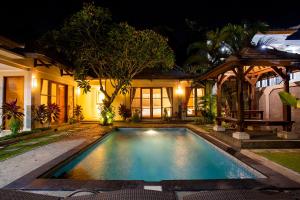 克罗柏坎Dura Villas Canggu Bali的夜间在房子前面的游泳池