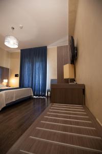 拉奎拉维基亚特勒克帕尼亚酒店的酒店客房,配有床和电视