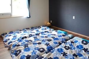 石垣岛石垣島北部一棟貸しコテージあちみぃん（achimiin）的卧室内的一张床铺,配有蓝色和白色的被子
