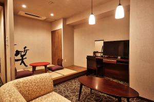 那霸Y's Inn Naha Oroku Ekimae的带沙发和平面电视的客厅