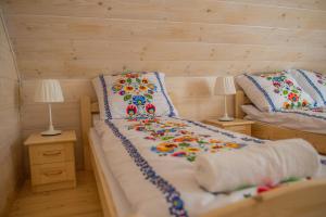 乌斯特龙Świerkowy Raj的一间卧室配有两张带枕头和两盏灯的床。