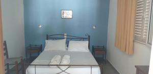 阿基奥斯基利考斯Apostolakis Rooms的蓝色客房的一张床位,配有两个白色枕头