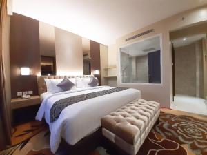 哥伦打洛省ASTON Gorontalo Hotel & Villas的一间带大床和浴缸的大卧室