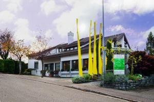 穆尔海姆Boutique-Hotel im Weingarten的前面有黄色旗帜的建筑