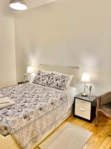 波尔图Porto Sé Apartamentos的一间卧室配有一张床和一张带两盏灯的桌子。