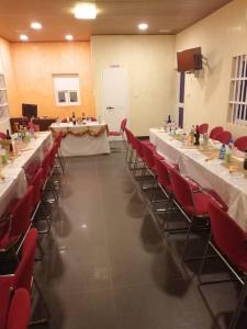 科托努Residence Ivoire Cotonou的配有长桌子和红色椅子的房间
