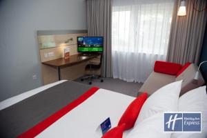 福克斯通快捷假日福克斯顿海峡假日酒店的酒店客房配有一张床、一张书桌和一台电视。