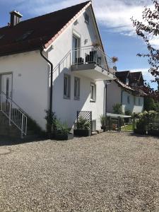 PörnbachFerienwohnung im Herzen der Holledau的带阳台的白色房屋和砾石车道