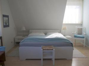 乌尔丁根-米赫尔霍芬Ferienhaus und Gästezimmer Cleo的白色的卧室设有一张大床和一个窗户