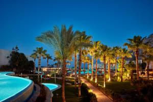 科林比亚Atlantica Aegean Blue的棕榈树和夜间游泳池的度假村