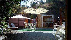 阿尔加罗沃Eldorado Yurt的一个带桌子和遮阳伞的庭院和帐篷
