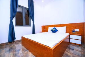 土龙木市SUN HOTEL的一间卧室配有一张带木制床头板的床