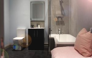 彭布罗克郡The Globe Angle的浴室配有卫生间、盥洗盆和浴缸。