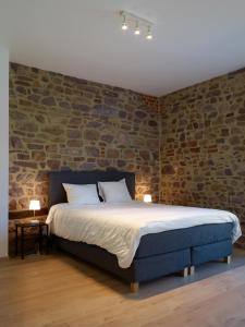 普罗丰德维耶Le Merle - Bois-de-Villers的一间卧室配有一张砖墙床