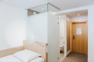 林茨圣马格达莱纳酒店的一间带床的小卧室和一间浴室