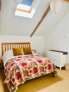 利明顿Vinegar Hill Pottery的一间卧室配有一张带花卉床罩的床和窗户。