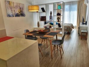 布宜诺斯艾利斯Exclusivo estudio a metros de la Rural y la Embajada的厨房以及带桌椅的起居室。