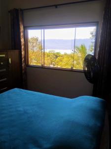 伊利亚贝拉Chalé da Katia的一间卧室设有蓝色的床和大窗户