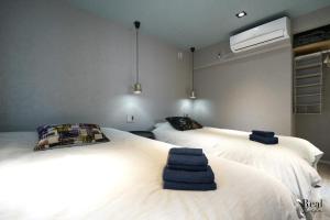 东京Real Life AOYAMA的一间卧室配有两张带毛巾的床