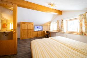 圣安东阿尔贝格Haus Rosmarie的一间卧室配有一张床、一个水槽和一台电视