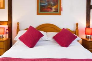 埃文河畔斯特拉特福Moss Cottage的一张带两个粉红色枕头的白色床