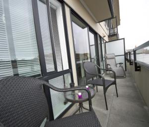 维多利亚都市田园酒店的大楼内的阳台配有椅子和窗户。