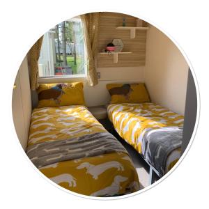 林肯Holiday Home Breaks At Tattershall Lakes的小房间设有两张床和窗户