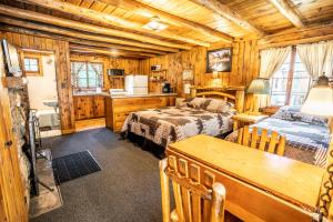 埃弗格林Colorado Bear Creek Cabins的小木屋卧室配有两张床和厨房