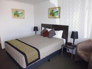 金格罗伊伯克威尔斯汽车旅馆的一间卧室配有一张床、一张沙发和一张桌子