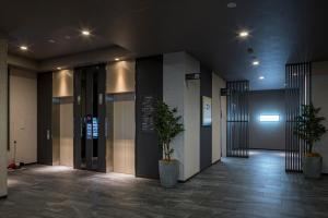 神栖市Hotel Route-Inn Kamisu的建筑里两棵盆栽的走廊