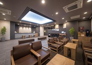 浜田市Hotel Route-Inn Hamada Ekimae的一间设有棕色椅子和大型天窗的等候室