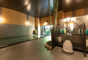 岸和田市Hotel Route-Inn Osaka Kishiwada -Higashikishiwada Ekimae Kansai Airport-的浴室设有游泳池,毗邻游泳池