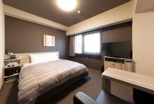 岸和田市Hotel Route-Inn Osaka Kishiwada -Higashikishiwada Ekimae Kansai Airport-的一间卧室配有一张床和一台平面电视
