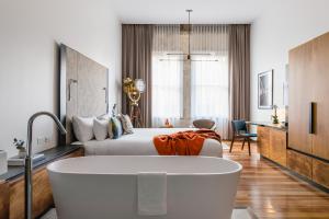 悉尼The Old Clare Hotel, Independent Collection by EVT的酒店客房配有一张床和浴缸。