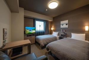 IchiharaHotel Route-Inn Ichihara的酒店客房设有两张床和一台平面电视。