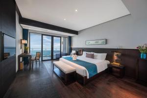 惠东惠州惠东双月湾檀悦豪生度假酒店的一间卧室设有一张大床,享有海景
