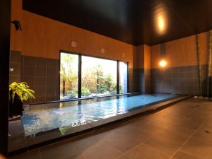 ChuoHotel Route-Inn Yamanashi Chuo的大型游泳池,位于带大窗户的房间内