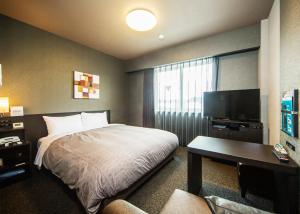 香取市Hotel Route-Inn Katori Sawara Ekimae的配有一张床和一台平面电视的酒店客房