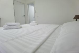 阿尔杰什河畔库尔泰亚Casa Sima的白色的床,配有白色的床单和毛巾