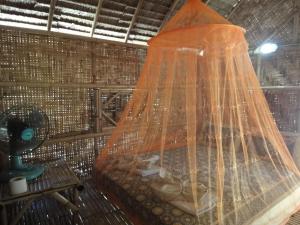 丽贝岛Varin Village Koh Lipe的一间卧室配有一张带蚊帐的床
