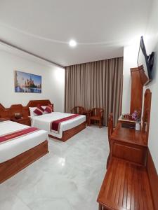 Bạc LiêuRoyal Hotel 2的酒店客房设有两张床和电视。