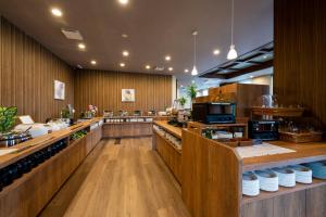 鹿沼Hotel Route-Inn Kanuma Inter的餐厅设有带木墙和柜台的厨房