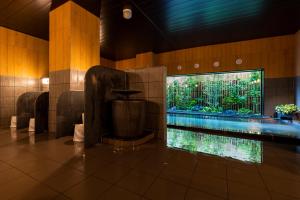 鹿沼Hotel Route-Inn Kanuma Inter的一座带大型水族馆的建筑中的游泳池