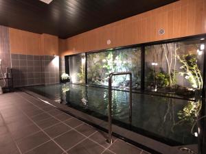增田Hotel Route-Inn Masuda的游泳池,浴室设有水族馆