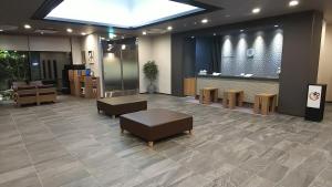 增田Hotel Route-Inn Masuda的大堂设有带沙发和桌子的等候区