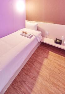台北单人房住宿空间 - 台北馆的卧室铺有木地板,配有白色的床。