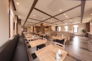 仓敷Hotel Route-Inn Kurashiki Mizushima的一间空餐厅,配有木桌和椅子