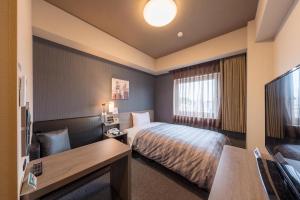 仓敷Hotel Route-Inn Kurashiki Mizushima的配有一张床和一台平面电视的酒店客房